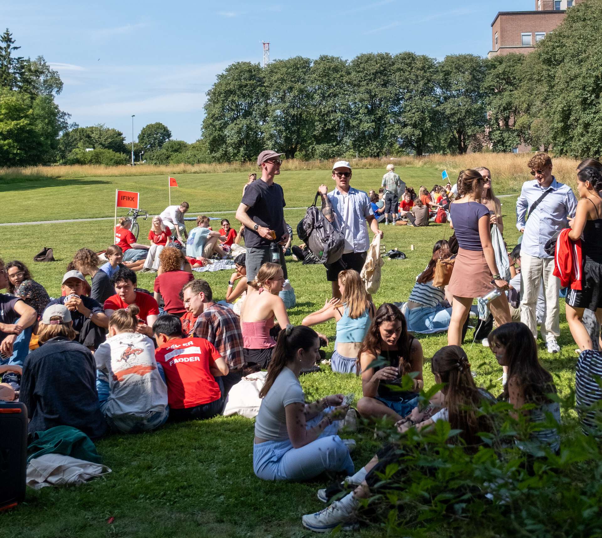 To studenter smiler og prater, hun ene har på en hatt.