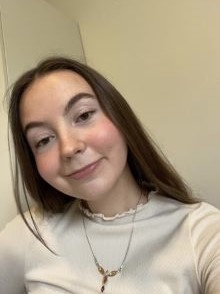 person, portrett, langt mørkt hår, smilende, hvit genger, smykke rund halsen